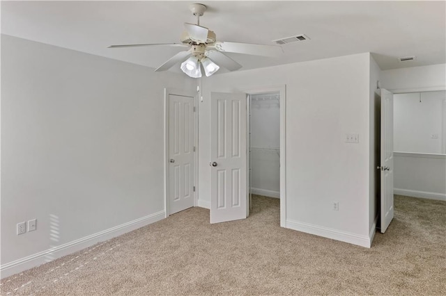 626 S Village Ln Unit A, Mandeville, LA 70471 - unfurnished bedroom featuring carpet floors, a walk in closet, baseboards, and a ceiling fan