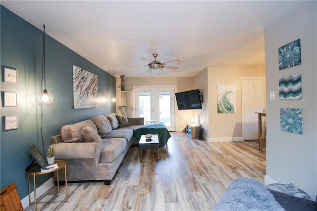 living room with light hardwood / wood-style flooring, ceiling fan, and french doors