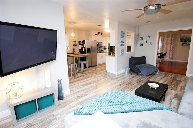 living room with ceiling fan and light hardwood / wood-style floors