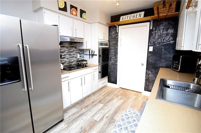 kitchen with tasteful backsplash, black electric cooktop, stainless steel fridge, double oven, and white cabinets