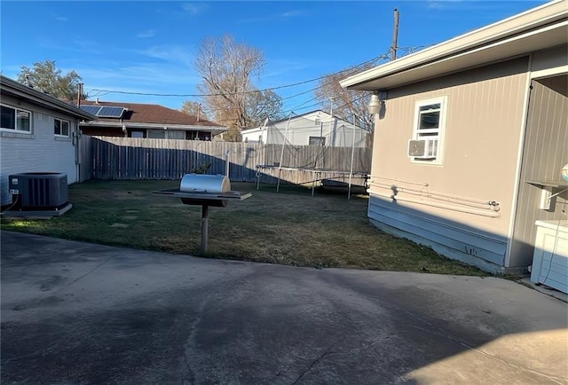 view of yard with cooling unit, a patio area, and a trampoline