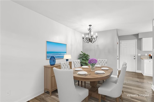 dining area with baseboards, a chandelier, and wood finished floors