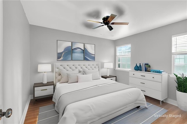 bedroom with a ceiling fan, baseboards, and wood finished floors