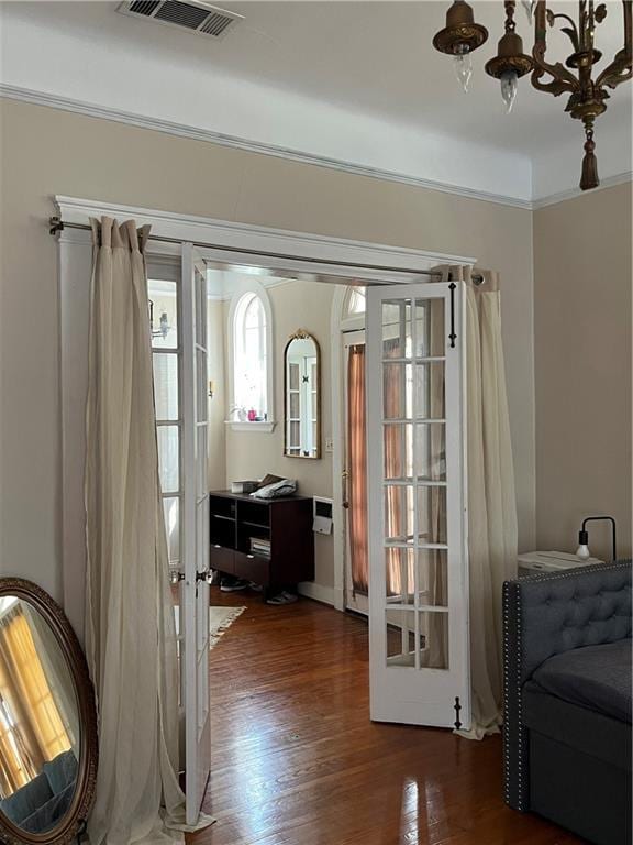 doorway featuring a notable chandelier, dark hardwood / wood-style flooring, and french doors