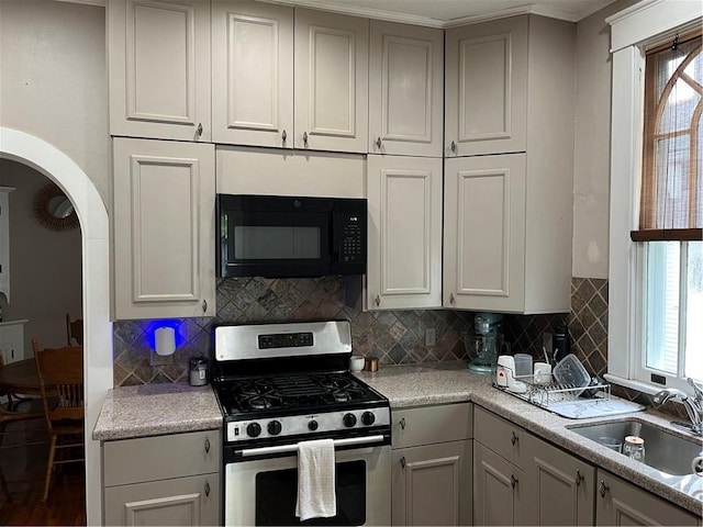 kitchen featuring sink, decorative backsplash, stainless steel gas range, and plenty of natural light