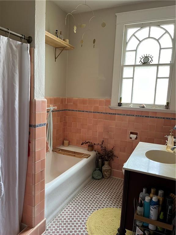 bathroom featuring vanity, separate shower and tub, and tile walls