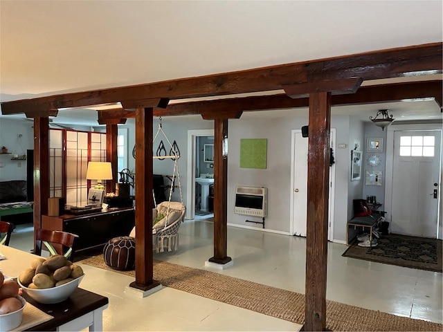 interior space featuring beamed ceiling and heating unit