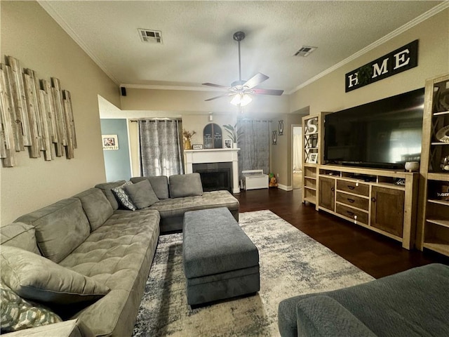 living room with ceiling fan, ornamental molding, dark hardwood / wood-style floors, and a textured ceiling