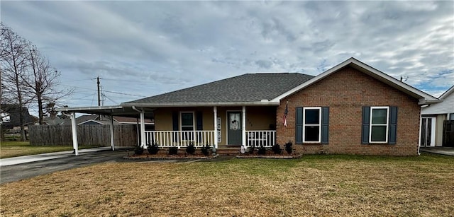 view of front facade featuring a carport, covered porch, and a front yard