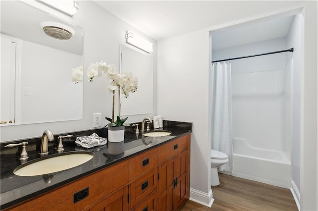 full bathroom featuring shower / tub combo with curtain, vanity, wood-type flooring, and toilet