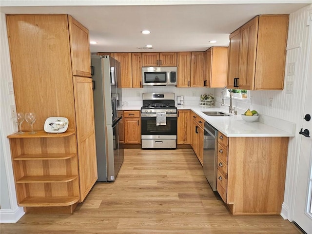 kitchen with decorative backsplash, stainless steel appliances, sink, and light hardwood / wood-style flooring