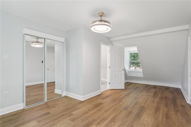 unfurnished bedroom featuring hardwood / wood-style floors and a closet