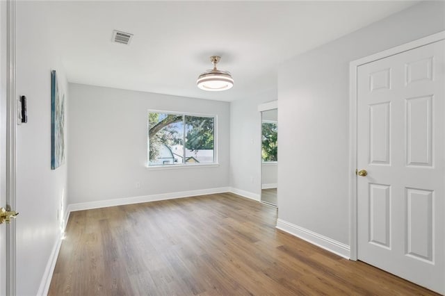 unfurnished room with hardwood / wood-style flooring