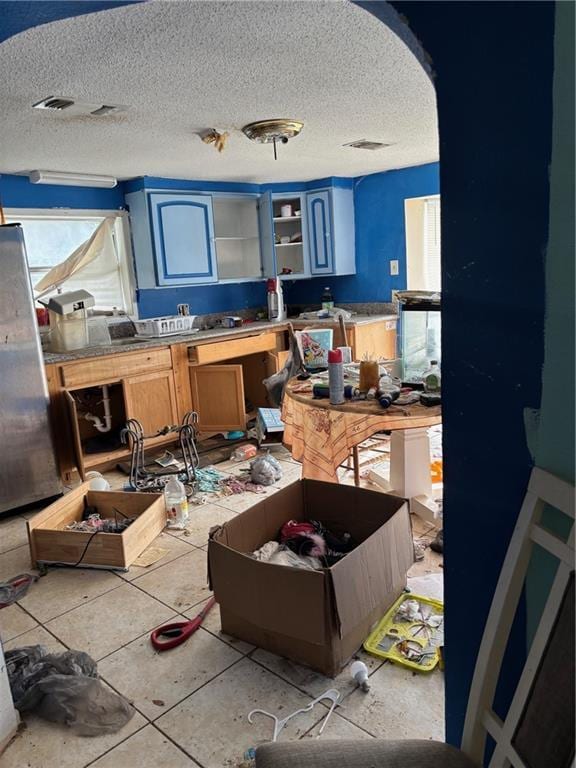 miscellaneous room with tile patterned flooring and a textured ceiling