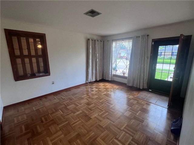 spare room featuring dark parquet flooring