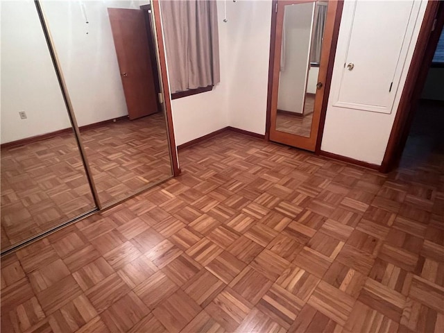 unfurnished bedroom featuring light parquet flooring and a closet