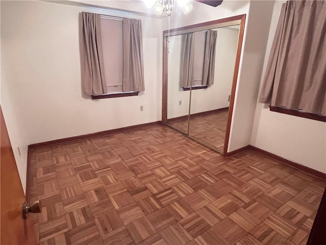 unfurnished bedroom with parquet flooring and a closet