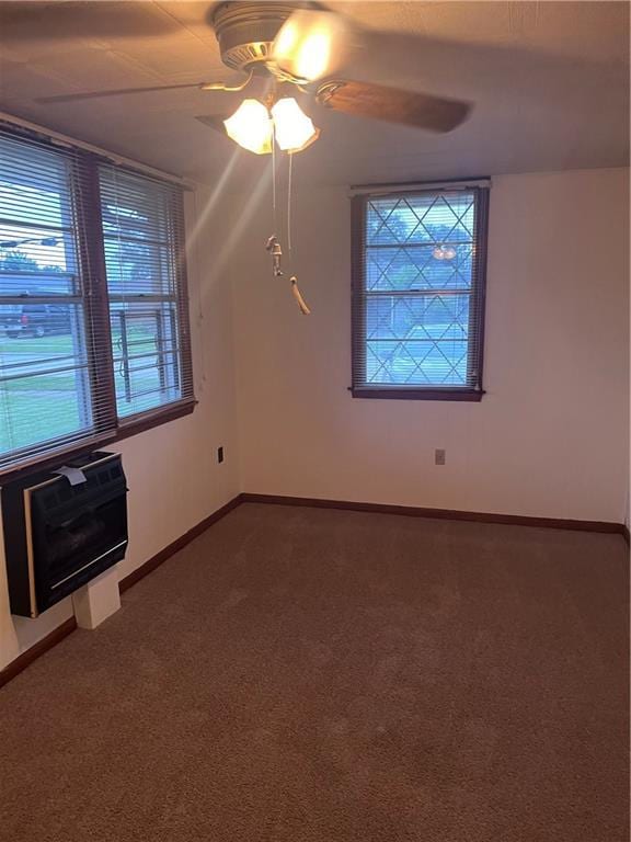 carpeted empty room featuring a wealth of natural light and ceiling fan