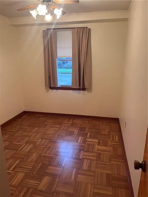 spare room featuring dark parquet flooring and ceiling fan