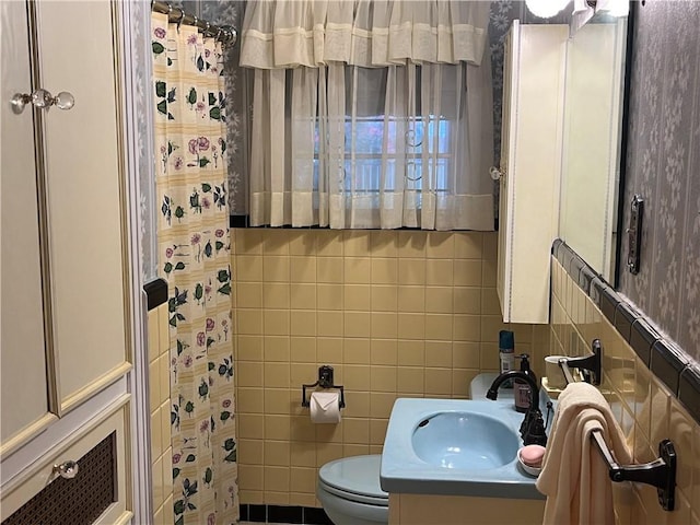 bathroom featuring vanity, toilet, and tile walls