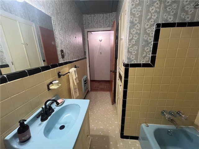 bathroom featuring vanity, heating unit, and tile walls