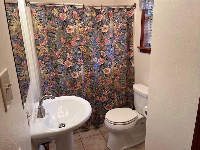 bathroom with tile patterned flooring, sink, and toilet