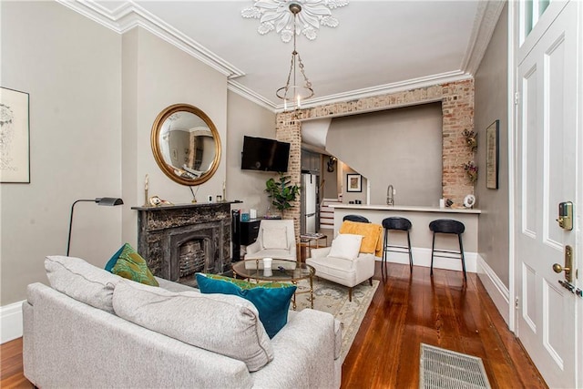 living room featuring sink, dark wood-type flooring, and ornamental molding