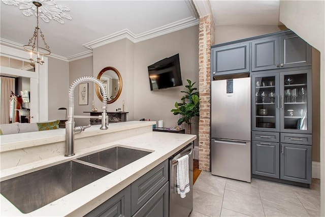 kitchen featuring sink, light tile patterned floors, gray cabinets, appliances with stainless steel finishes, and ornamental molding