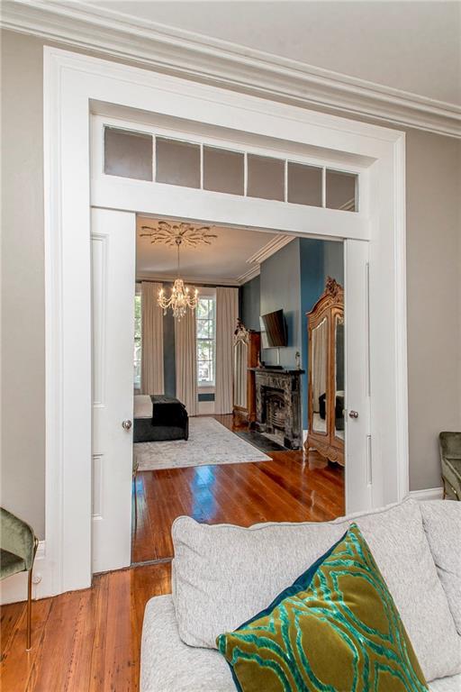 604 Esplanade Ave Unit 101, New Orleans, LA 70116 - living area with crown molding, wood-type flooring, and a chandelier