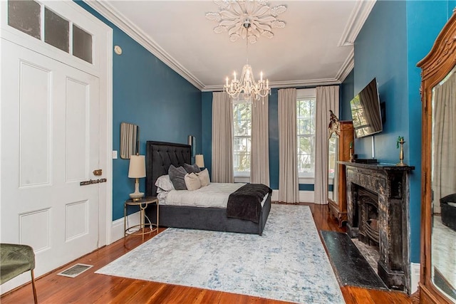 bedroom featuring crown molding, dark hardwood / wood-style floors, and a notable chandelier