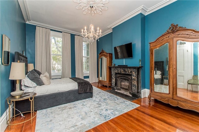 604 Esplanade Ave Unit 101, New Orleans, LA 70116 - bedroom with a chandelier, wood finished floors, crown molding, and a high end fireplace