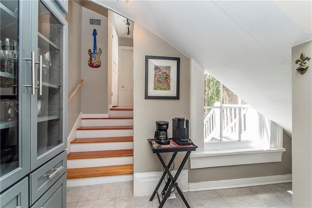 stairs featuring a healthy amount of sunlight and vaulted ceiling