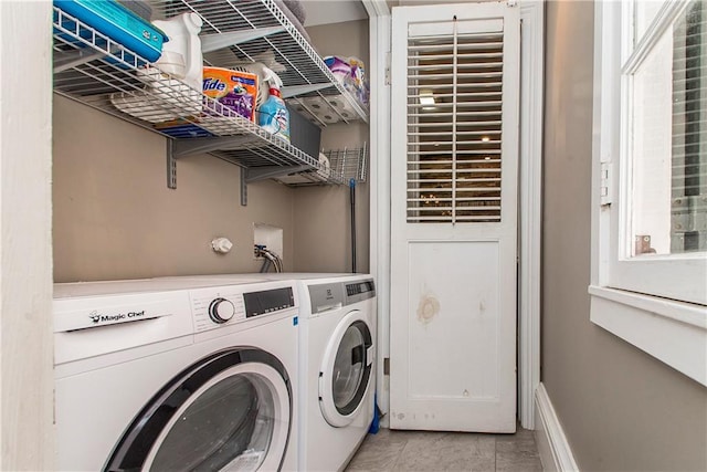 clothes washing area with washing machine and clothes dryer and light tile patterned floors