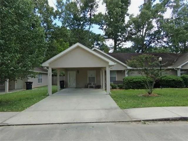 view of front of house with a carport and a front lawn