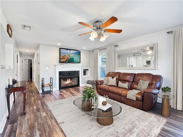 living room featuring ceiling fan and dark hardwood / wood-style flooring