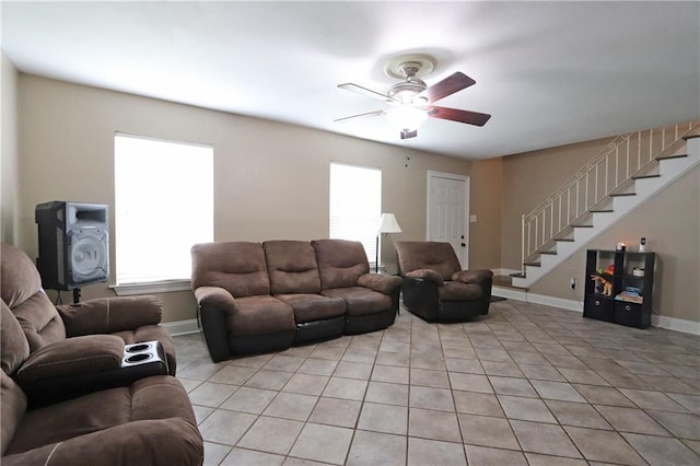 tiled living room with ceiling fan and a wood stove