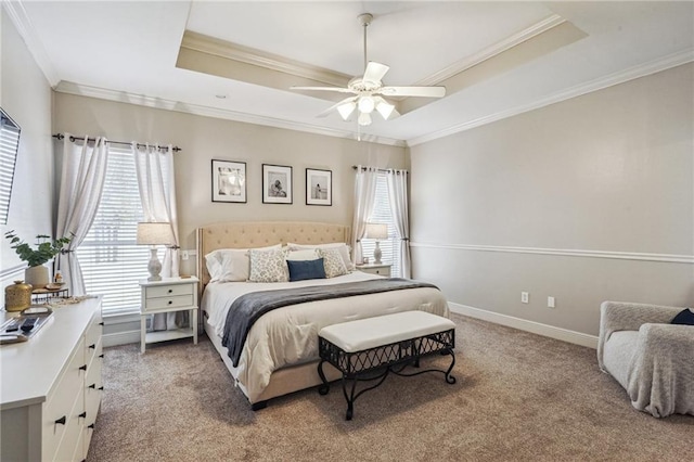 carpeted bedroom with multiple windows, a raised ceiling, and ceiling fan