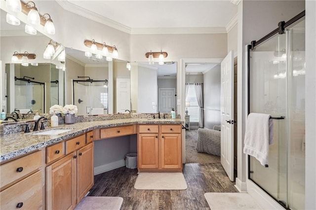 bathroom with vanity, hardwood / wood-style flooring, a shower with shower door, and ornamental molding