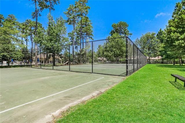 view of tennis court with a yard