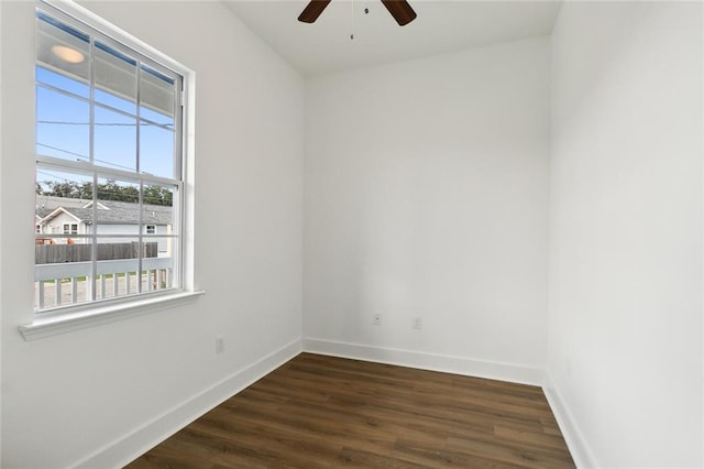 spare room with dark wood finished floors, baseboards, and ceiling fan