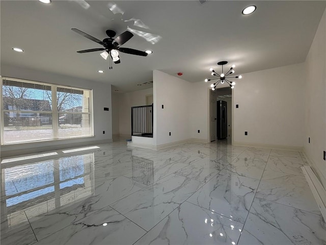 spare room with ceiling fan with notable chandelier