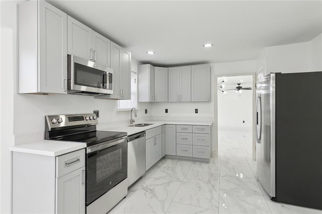 kitchen featuring marble finish floor, light countertops, stainless steel appliances, a sink, and recessed lighting