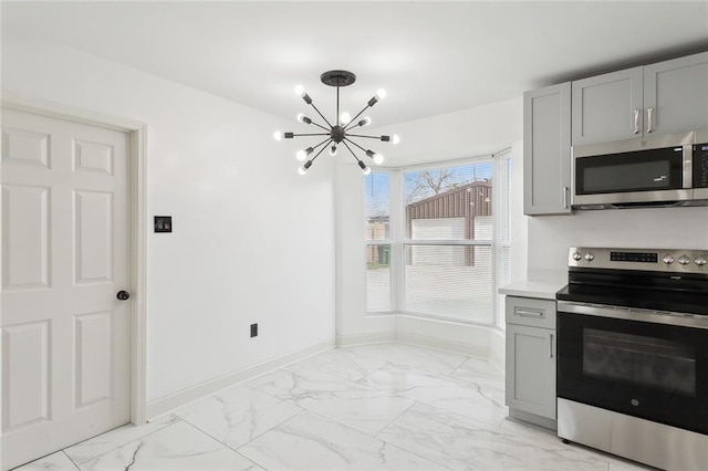 kitchen with marble finish floor, a notable chandelier, stainless steel appliances, gray cabinets, and baseboards