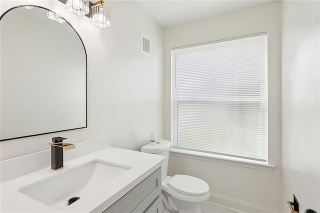 bathroom featuring a wealth of natural light, visible vents, vanity, and toilet