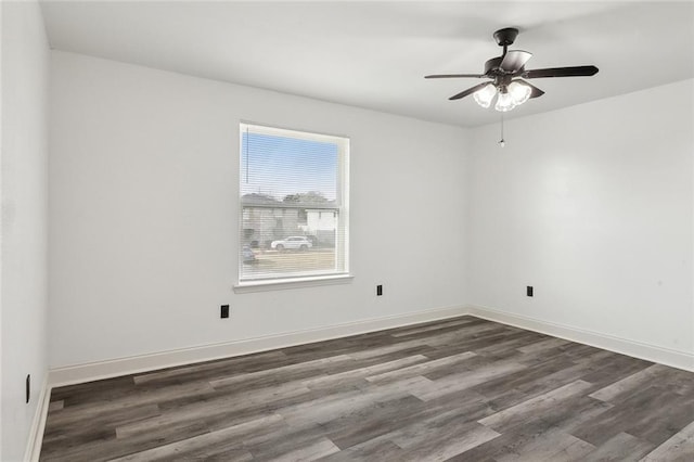 unfurnished room featuring dark wood-style flooring, a ceiling fan, and baseboards