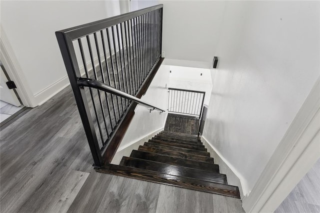 staircase with wood finished floors and baseboards