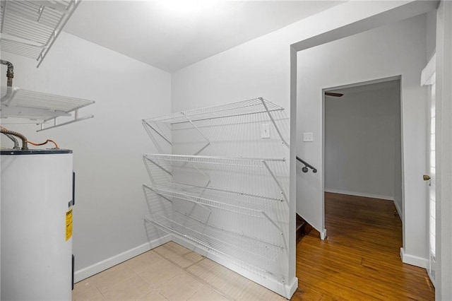 walk in closet with wood-type flooring and electric water heater