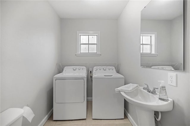 laundry room featuring independent washer and dryer, sink, and light tile patterned floors