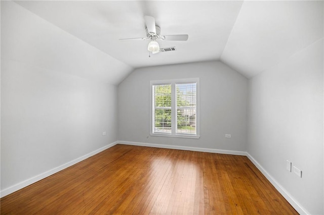 additional living space with hardwood / wood-style flooring, vaulted ceiling, and ceiling fan