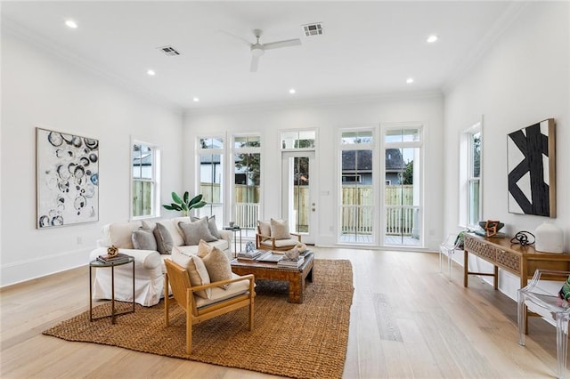 living room with ceiling fan, ornamental molding, and light hardwood / wood-style floors